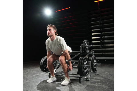 Black Hammer Strength multi-squat machine with weight plates and chrome bars on white background