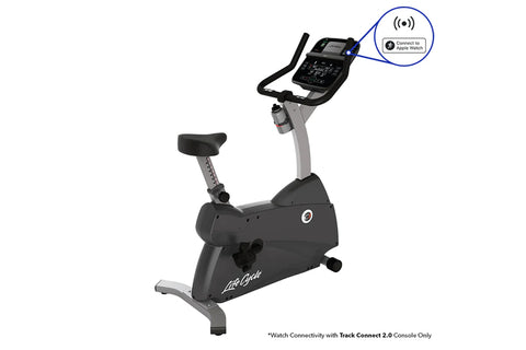 Black and gray upright exercise bike with digital console, black padded seat, and gray frame on white background