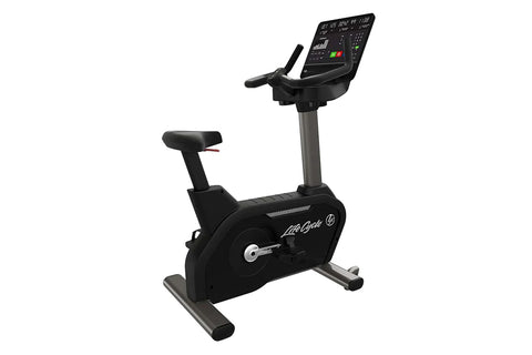Black Life Fitness upright exercise bike with digital display console, handlebars, and foot pedals on white background
