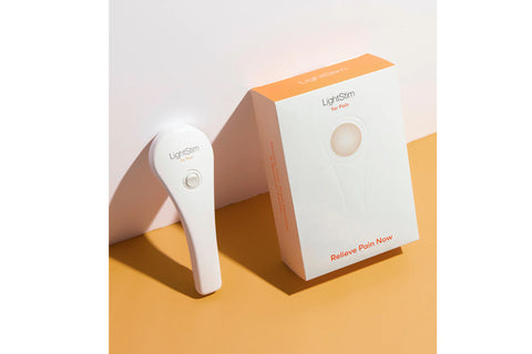 White handheld LED light therapy device with red light head on neutral background