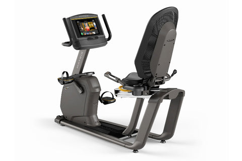 Matrix R50 recumbent exercise bike with black mesh backrest and gray frame, digital touchscreen console on adjustable arm, on
