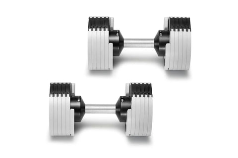 Pair of adjustable dumbbells with white and black weight plates, metal handles, and grip ridges on white background