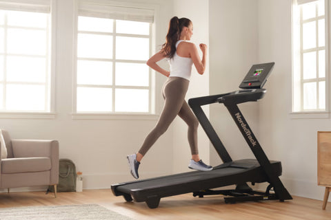 Black NordicTrack EXP 7i treadmill with digital console display and cushioned running deck on white background