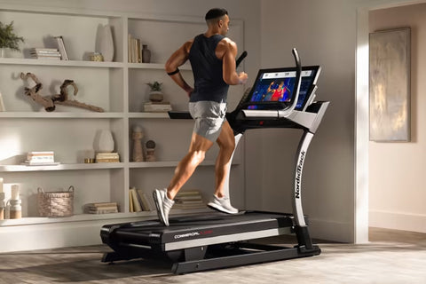 NordicTrack X32i commercial treadmill with black and gray frame, curved handrails, and digital display console on white backg