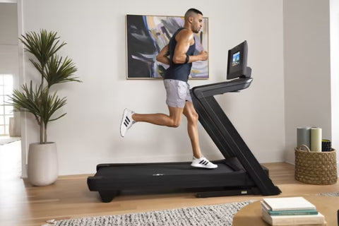 Black NordicTrack treadmill with Z-shaped frame and attached display screen showing workout video, on white background