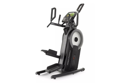 Black and gray upright exercise bike with digital touchscreen display, dual moving handlebars, and textured foot pedals on wh