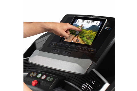 Black folding treadmill with digital display console, gray accents, and red foot pedals on white background