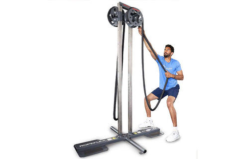 Man in red shirt using gray and black upright rope trainer with dual handles on white background