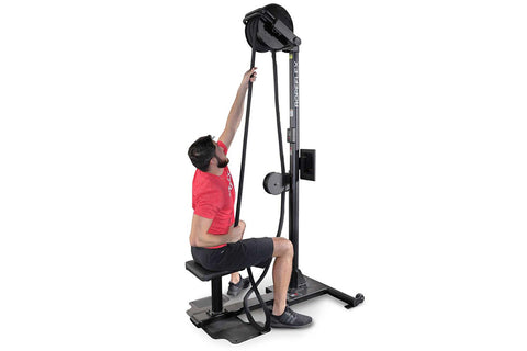 Man in red shirt using black upright rope trainer machine with pulley system on white background