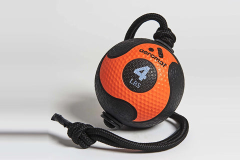 Orange and black rubber medicine ball with textured surface, black braided rope handle and cord attachment on white backgroun