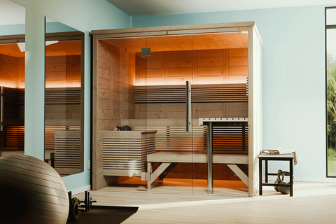 Almost Heaven Everwood indoor sauna with light wood construction, glass front doors, tiered wooden benches, and black heater 