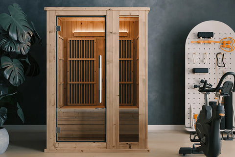 Light wood infrared sauna with glass door, interior heater panel, and bench seating on white background