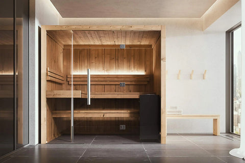 Light wood indoor sauna with glass front doors, wooden benches, and black heater stove on dark floor