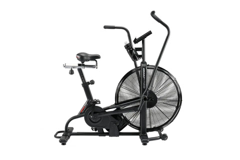 Black upright stationary air bike with large fan wheel, padded seat, dual handlebars, and digital display on white background