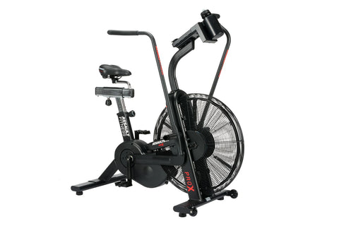 Black air bike with large fan wheel, upright handlebars, and stationary seat on white background