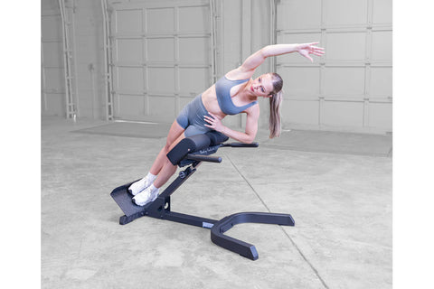 Body-Solid 45-degree ab and back hyperextension bench with navy blue and black padded seat, adjustable steel frame, and foot 