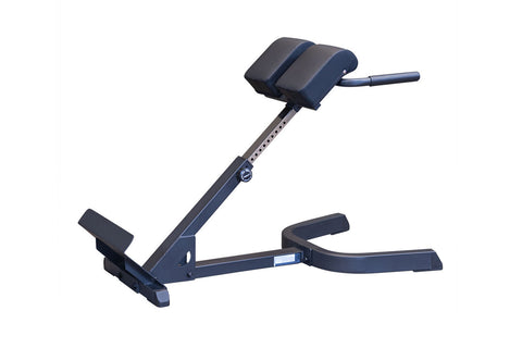 Body-Solid 45-degree ab and back hyperextension bench with navy blue and black padded seat, adjustable steel frame, and foot 