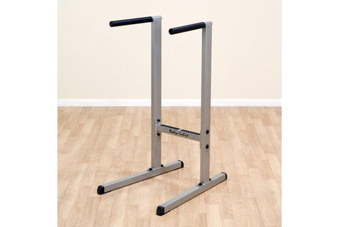 Body-Solid dip station with silver metal frame, black rubber handles, and wide base on white background