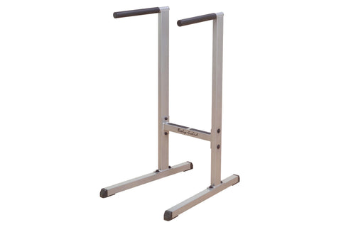 Body-Solid dip station with silver metal frame, black rubber handles, and wide base on white background