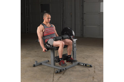 Black leg extension and curl machine with padded seat, backrest, and leg attachments on white background