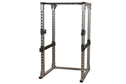 Body-Solid Pro Power Rack with gray and black steel frame, adjustable safety bars, and perforated upright posts on white back
