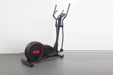 Black and red elliptical cross-trainer with dual handles and foot pedals on gray floor, white background