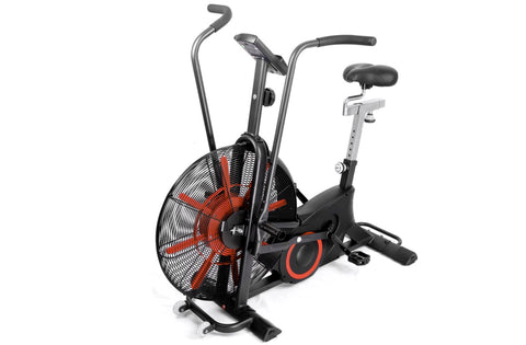 Black and red air exercise bike with large fan wheel, upright handlebars, padded seat, and digital display on white backgroun