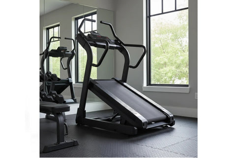 Black incline trainer treadmill with angled running deck, dual handrails, and digital display on white background