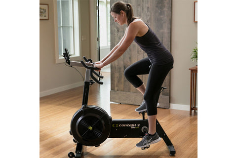 Concept2 BikeErg stationary exercise bike with black frame, gray accents, curved handlebars, and large black flywheel, on whi