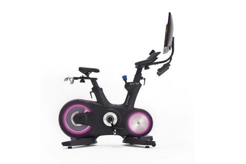Black stationary exercise bike with pink illuminated wheels, digital console, and adjustable tablet holder on white backgroun