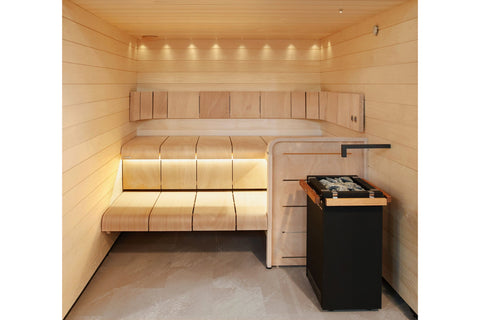 Black metal sauna heater with gray stones in top chamber and door with handle, Harvia brand logo visible