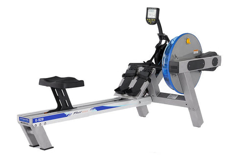 FluidRower E520 Evolution commercial rowing machine with gray frame, blue accents, digital monitor, and black footrest on whi