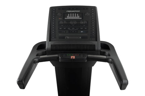 Black Freemotion t10.9b REFLEX treadmill with digital display console, handrails, and cushioned running deck on white backgro