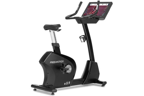 Freemotion u22.9 black upright exercise bike with digital display console and padded seat, on white background
