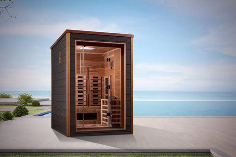 Two-person infrared sauna with dark gray exterior, wood trim, and glass door revealing cedar interior with heating panels and