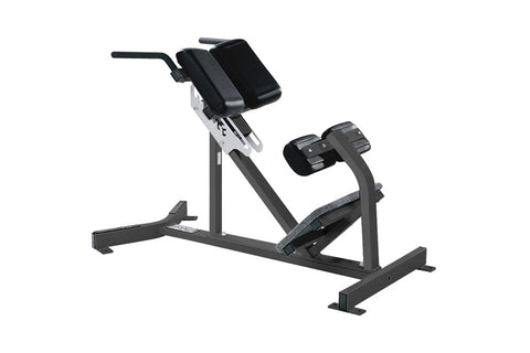 Black and gray Hammer Strength back extension machine with adjustable back pad, footplate, and handlebar on white background