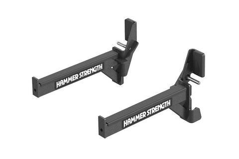 Pair of black Hammer Strength weight rack bar catchers with adjustable arms and metal pins, flat lay on white background