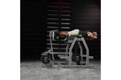 Hammer Strength black glute-ham reverse hyper combo bench machine with padded seat and leg attachment on white background