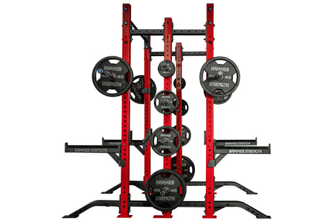 Hammer Strength red and black half combo power rack with loaded Olympic weight plates and barbell sleeves in gym setting