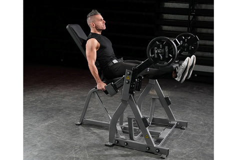 Black plate-loaded leg extension machine with padded seat and backrest, dual handles, and adjustable foot platforms on white 