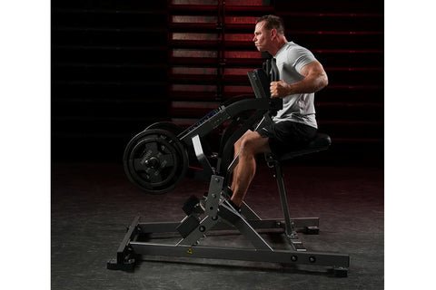 Black plate-loaded iso lateral row machine with padded chest support, dual handles, and foot platform on white background
