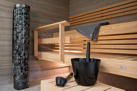Black plastic sauna pail with wooden handle and matching black ladle, on white background