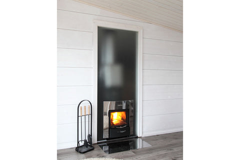 Black wood-burning stove with active flames in white aluminum frame fireplace insert, displayed in modern white shiplap room 