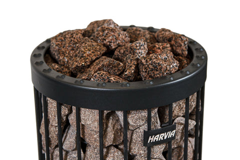 Pile of brown granite sauna stones with rough textured surface on white background