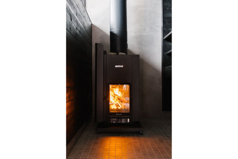Black protective sheath for sauna heater with mounting brackets and ventilation slots, angled view on white background