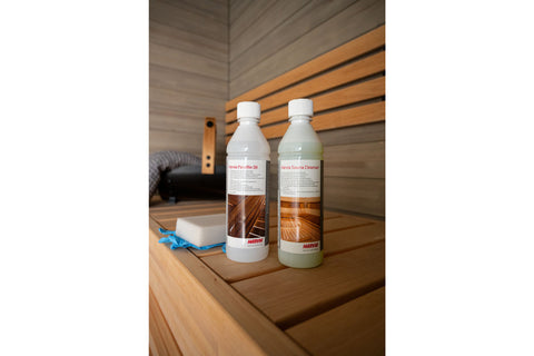 Harvia Sauna Care Set with two bottles and accessories on wooden sauna bench background