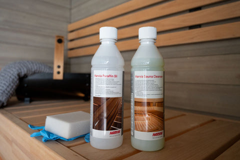 Harvia Sauna Cleanser bottle with red cap and white liquid, featuring wooden sauna interior on label, on white background