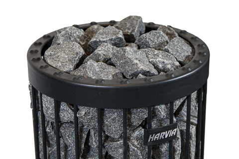 Harvia sauna heater stones, gray diabase rocks in black metal basket with riveted rim on white background