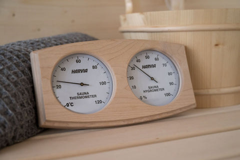Harvia sauna thermo-hygrometer with light wood frame, dual analog gauges measuring temperature and humidity on white backgrou