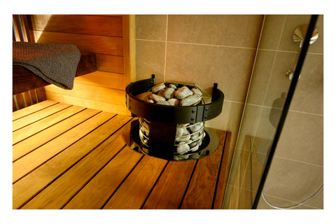 Harvia Spirit electric sauna heater with gray stones in tiered stainless steel basket on white background